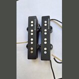 Dvě černé elektrické snímače typu rail s kovovými póly. Na obou je svisle napsán bílý text DUNCAN DESIGNED. Snímače mají připojené vodiče v černé a b…