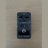 Černý efekt pedál s nápisy THE SILENCER a noise gate/effects loop. Na horní části jsou dva ovládací knoflíky s popisky RELEASE a THRESH, uprostřed je…