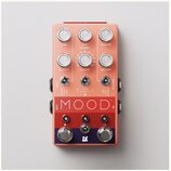 Růžový efekt pedál s nápisem MOOD. Na horní části jsou šest otáčivých ovladačů s popisky TIME, MIX (RAMP), LENGTH a MODIFY. Uprostřed se nachází přep…