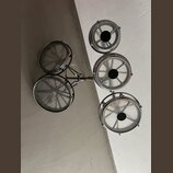 Sada pěti malých kovových bubnů v chromovaném provedení, které jsou upevněny na společném kovovém držáku. Bubny mají průhledné membrány a černé střed…
