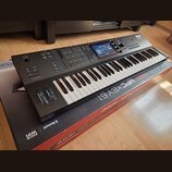 Černý MIDI kontrolér s klaviaturní klávesou a pody v horní části. Na přístroji jsou nápisy AKAI a MPC KEY 61, v pravé horní části je barevný displej.…