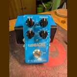 Modrý efekt pedál s nápisy FLASHBACK, DELAY AND LOOPER a tc electronic. Na horní části jsou čtyři černé ovládací knoflíky s popisky DELAY, FEEDBACK,…