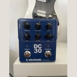 Modrý kytarový pedál s nápisy DC 30, tc electronic a AMPWORX. Zařízení má šest černých otočných ovladačů s popisky NORMAL, BRILLIANT, LEVEL, BASS, TR…