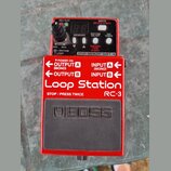 Červený efekt pedál Loop Station RC-3 značky BOSS. Horní panel obsahuje dva digitální displeje, ovládací knoflík a tlačítka s nápisy REC PLAY, WRITE…