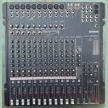 Černý mixovací pult s nápisem YAMAHA a označením modelu MG166CX. Zařízení obsahuje vícevstupní sekci s knoflíky pro Gain, High, Mid a Low, řadu posuv…