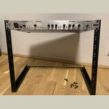 Stříbrný rackový procesor s černými ovládacími prvky umístěný na černém kovovém stojanu. Na zařízení jsou nápisy Focusrite, DISCRETE PREAMP, OPTICAL…
