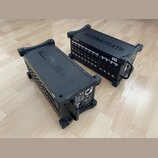 Dvě černé rackové jednotky značky ALLEN&HEATH umístěné na dřevěné podlaze. Jednotka vpravo nese nápis DX168 MixerExpand. Obě zařízení mají na horní s…