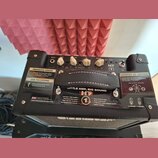 Černý kytarový kombo zesilovač s ovládacím panelem, který obsahuje knoflíky INPUT, GAIN, VOLUME, EQ a REVERB. Na přední straně je nápis HT, logo Blac…