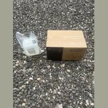 Kartonová krabice s nápisy STARVLUX, M-Fog 1000 a DMX Fog Machine. Vedle krabice je plastová láhev s bílou tekutinou v průhledném sáčku, na které je…
