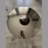 Kruhový činel z lesklého kovu s viditelným rýhováním. Na povrchu je černý nápis AAX a pod ním text X-Plosion Crash 18"/45 cm. Povrch je v dobrém stav…
