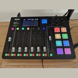 Černý studiový mixér s nápisy RØDE, RØDECASTER PRO a APHEX On board. Zařízení obsahuje digitální displej s VU metry, pět posuvníků, několik podsvícen…