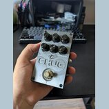 Kytarový efekt pedál v kovovém stříbrném provedení s nápisem CHUG. Na horní části jsou šest černých otočných ovladačů s popisky BASS / DEPTH, MIDDLE,…