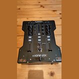Černý DJ mixér s nápisem ALLEN&HEATH v horní části a XONE:23C ve spodní části. Zařízení obsahuje několik faderů, otočných knoflíků a tlačítek s popis…