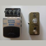 Dvě kytarové efektové pedály z ptačí perspektivy. Levý je stříbrný s černým spínacím pedálem a nápisy DIGITAL REVERB, DR600 a behringer. Má tři ovlád…