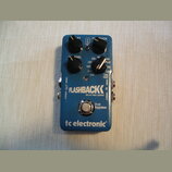 Modrý efekt pedál s nápisy FLASHBACK DELAY AND LOOPER a tc electronic. Zařízení má čtyři černé ovládací knoflíky s popisky LEVEL, DYN, LOFI, TAPE, AN…