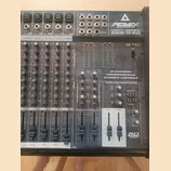 Šedý 12kanálový mixážní pult s nápisy PEAVEY, UNITY SERIES a 2002-12 RQ. Na přístroji je text 12 CHANNEL PROFESSIONAL STEREO CONSOLE a v pravém dolní…