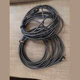 Dvě smotaná audio kabela v šedé barvě. Na kabelech je opakovaně bílý nápis Roland Professional Audio Cable a na jednom z nich je černý textilní pásek…