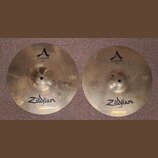 Dvě mosazné činely značky Zildjian. Levý činel nese nápisy A CUSTOM a HIHAT BOTTOM 14" 35,56 cm. Pravý činel má nápisy A CUSTOM a HIHAT TOP 14" 35,56…