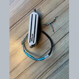 Bílý humbucker s dvěma černými polosnovými kryty snímačů. Na spodní části je svisle napsáno logo DiMarzio. Snímač má připojovací kabely v různých bar…