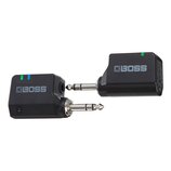 Dvě černé bezdrátové vysílače/přijímače značky BOSS s 6,3mm jack konektory. Na těle obou zařízení je šedé logo BOSS a zelená kontrolní LED dioda. Lev…