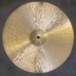 Kruhový mosazný činel s kovaným povrchem a viditelnými důlky. V horní části je vyryto logo Paiste. Povrch vykazuje běžné známky používání a drobné šk…