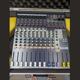 Modrý mixážní pult v hliníkovém kufru s pěnovou výplní. Na přístroji jsou vidět nápisy "exicon" a "Soundcraft EFX8". Zařízení obsahuje osm vstupních…