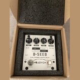 Bílý efekt pedál D-SEED DUAL CHANNEL DIGITAL DELAY značky JOYO v kartonové krabici s pěnovou výplní. Na horní straně jsou čtyři černé ovládací knoflí…