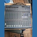 Šedý mixážní pult značky YAMAHA, model MX12/4. Zařízení obsahuje několik vstupních kanálů s posuvníky, knoflíky pro gain a ekvalizaci a sekci ST GRAP…