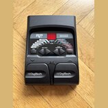 Černý kytarový procesor s nápisy RP 55 a MODELING GUITAR PROCESSOR. Zařízení obsahuje červený digitální displej, několik ovládacích tlačítek a dva pe…