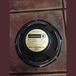 Fotografie znázorňuje zadní stranu černého reproduktoru. Uprostřed je bílý štítek s nápisy: Celestion, MADE IN ENGLAND, Model number G12M, Power capa…
