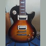 Elektrická kytara s trupem v barevnosti sunburst a černým pickguardem. Na přepínači je viditelný nápis RHYTHM TREBLE a na spodním snímači je nápis R.…