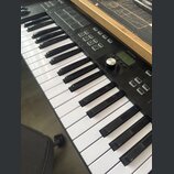 Černý MIDI kontrolér s klávesnicí. Na horním panelu je vidět nápis ARTURIA, sada padů a ovládací tlačítka s popisky Octave, Octave, Chord a Arp. Povr…