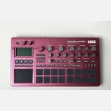 Bordeaux červený sampler KORG electribe sampler MUSIC PRODUCTION STATION. Zařízení obsahuje displej, několik otočných potenciometrů a mřížku šestiдес…