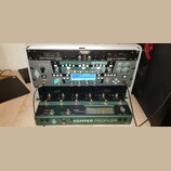 Stříbrný transportní kufr obsahuje v horní části kytarový zesilovač s nápisy MESA, 20/20 Dyna-Watt-Power a EL-84 AllTube Stereo. Pod ním je umístěn z…