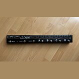 Černý pedálboard s nápisy JOYO PXL-PRO a DOUB 4 CHANNEL FX PEDAL SWITCHING SYSTEM. Zařízení obsahuje čtyři stomečovací spínače označené písmeny A, B,…