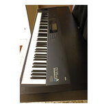 Černý digitální klavír s klasickou klávesnicí. Na pravé straně korpusu je nápis KORG a vedle něj označení 01/W ProX MUSIC WORKSTATION. V horní části…