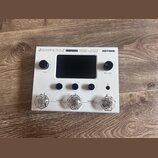 Bílý efektový procesor Hotone Ampero Stomp. Na horní hraně je nápis AMPERO STOMP, CDCM HD Gen 2 Amp Modeler / Effects Processor a logo HOTONE. Zaříze…