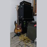 Na fotografii je elektrická basová kytara s barevným přechodem (sunburst), hnědým pickguardem a světle hnědým hnedem krčkem. Na hlavě nástroje je vid…