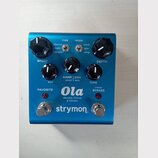Modrý efekt pedál s nápisy Ola, dBucket Chorus & Vibrato a logem strymon. Na horní straně jsou tři černé otočné knoflíky s popisky SPEED, MIX a DEPTH…