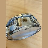 Stříbrný kovový malý buben s chromovaným povrchem. Na korpusu je umístěno kulaté logo s nápisem Gretsch, ORIGINAL SINCE 1881. Na horním obruči je vid…