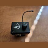 Černý kovový box s jedním ovládacím knoflíkem a tenkou anténou. Na přední straně je bílé logo s nápisem Myers. Box je upevněn čtyřmi křížovými šrouby…