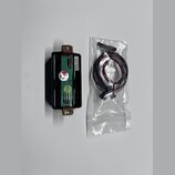 Fotografie zobrazuje elektronický modul v černém plastovém pouzdře a samostatný kabelový svazek v průhledném plastovém sáčku. Na modrém plošném spoji…