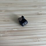 Černý kytarový pedál v kovovém provedení s kovovým spínacím tlačítkem. Na boční straně je vidět stříbrné logo a nápis GRADO. Povrch pedálu vykazuje m…