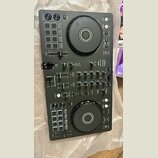 Černý DJ kontrolér s dvěma velkými jog-koly astředovými tlačítky. Na přístroji je vidět nápis Pioneer DJ a označení modelu DDJ-FLX4. Povrch obsahuje…