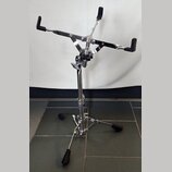 Chromovaný stojan na noty s černými plastovými úchvaty a černou deskou. Na spodní části teleskopické nohy je viditelný nápis YAMAHA. Stojan stojí na…