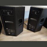 Dva černé aktivní reproduktory v plastových bednách s úchopovými madly. Na zadním panelu obou kusů je bílý nápis RCF TT 22A HIGH DEFINITION TOUR LINE…