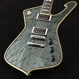 Elektrická kytara s tmavě zeleným povrchem, který má výrazný efekt praskání. Na hmatníku je viditelný nápis PAUL STANLEY. Nástroj má dva humbuckery,…