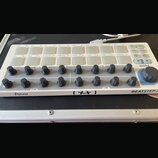 Bílý MIDI kontrolér s názvy Arturia a BEATSTEP Controller & Sequencer. Zařízení obsahuje dvě řady bílých čtvercových padů, 16 černých otočných knoflí…