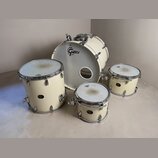 Sada bicích bubnů v krémové barvě s chromovaným hardwarem. Na přední kožeh basového bubnu je černé logo GRETSCH. Ostatní bubny mají na korpusu malé č…