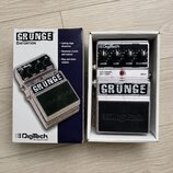 Fotografie zobrazuje efekt pedál v originální krabici. Na pedálu i na krabici je výrazný nápis GRUNGE a logo DigiTech. Zařízení má stříbrný kovový po…